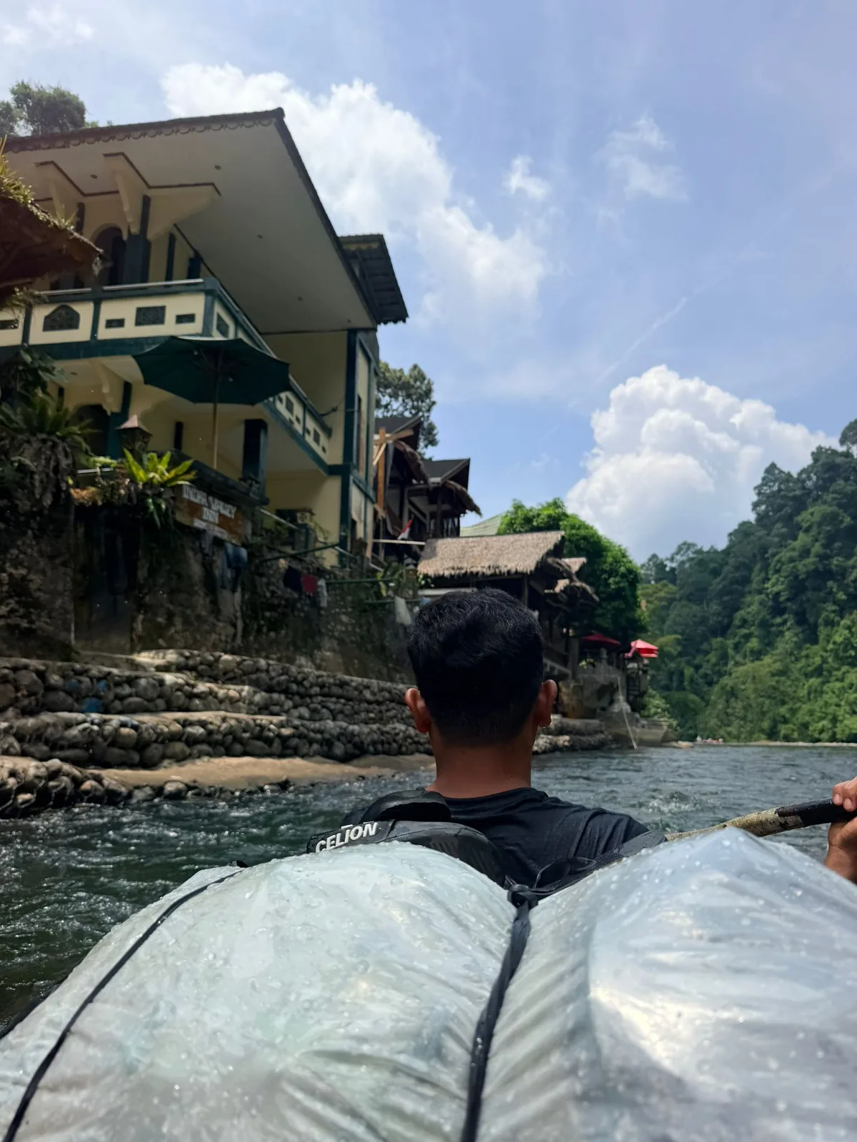 Traveler walking through a green Bukit Lawang village path